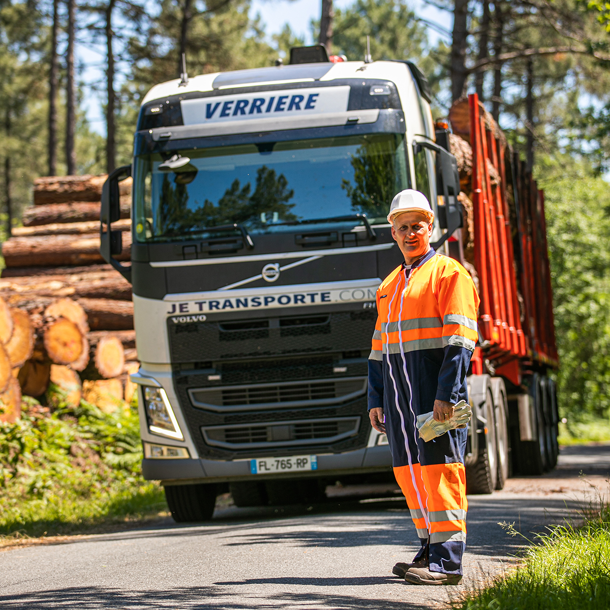 Conducteur devant son camion au milieu de la forêt